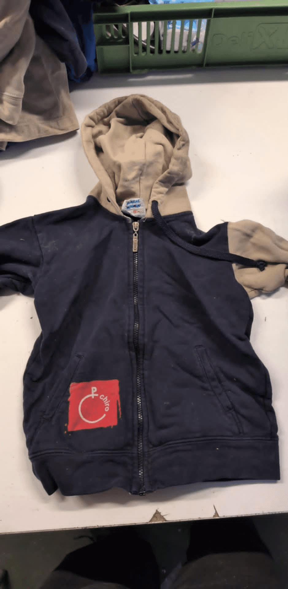 a blue and tan hoodie with a red c on it