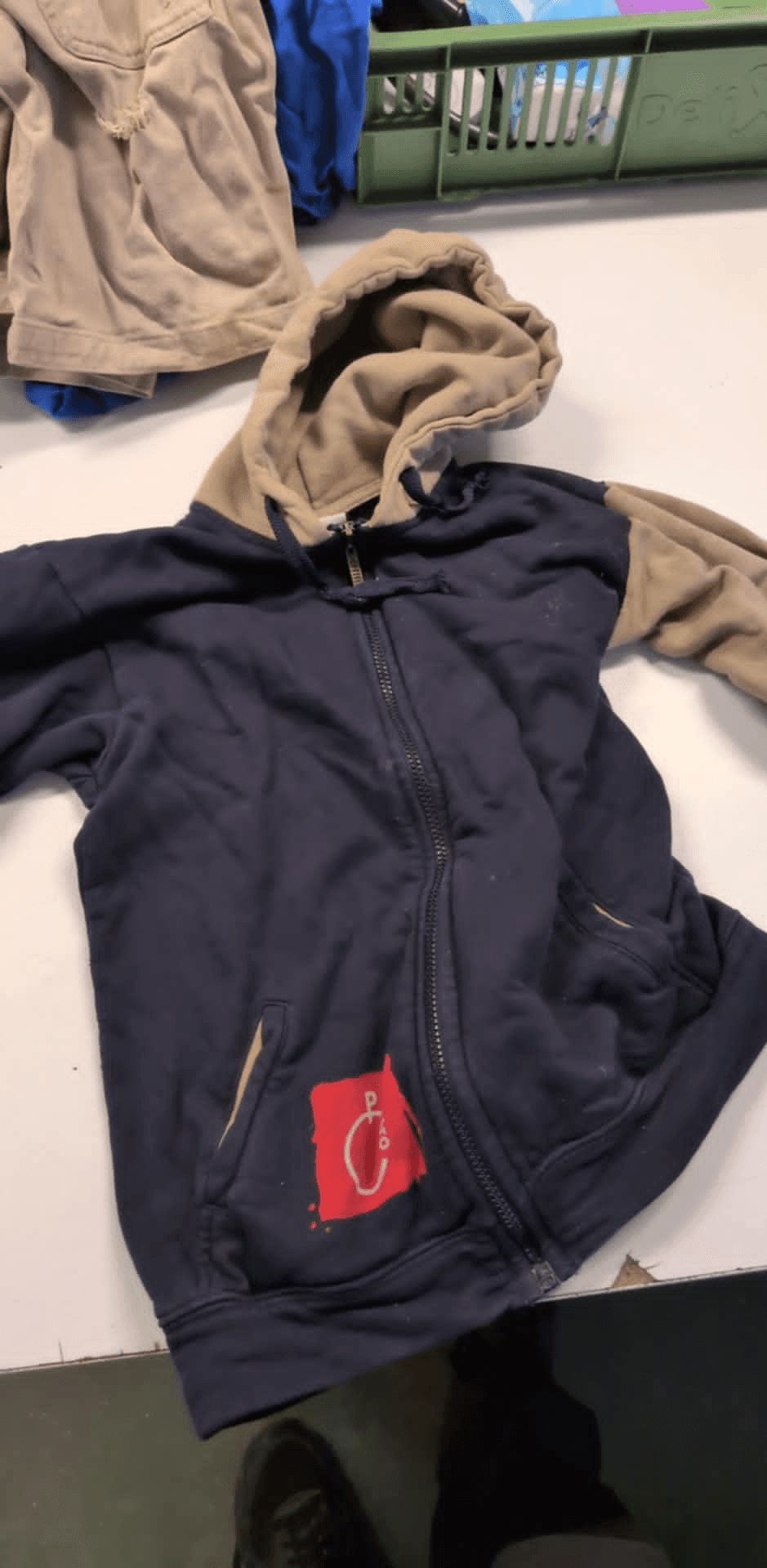 a blue hoodie with a red c on the pocket