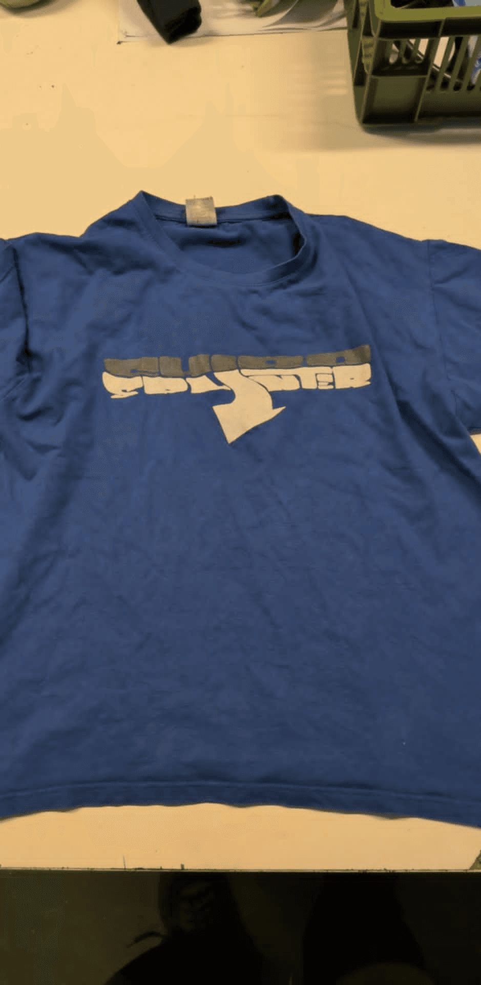 a blue shirt with the letter t on it