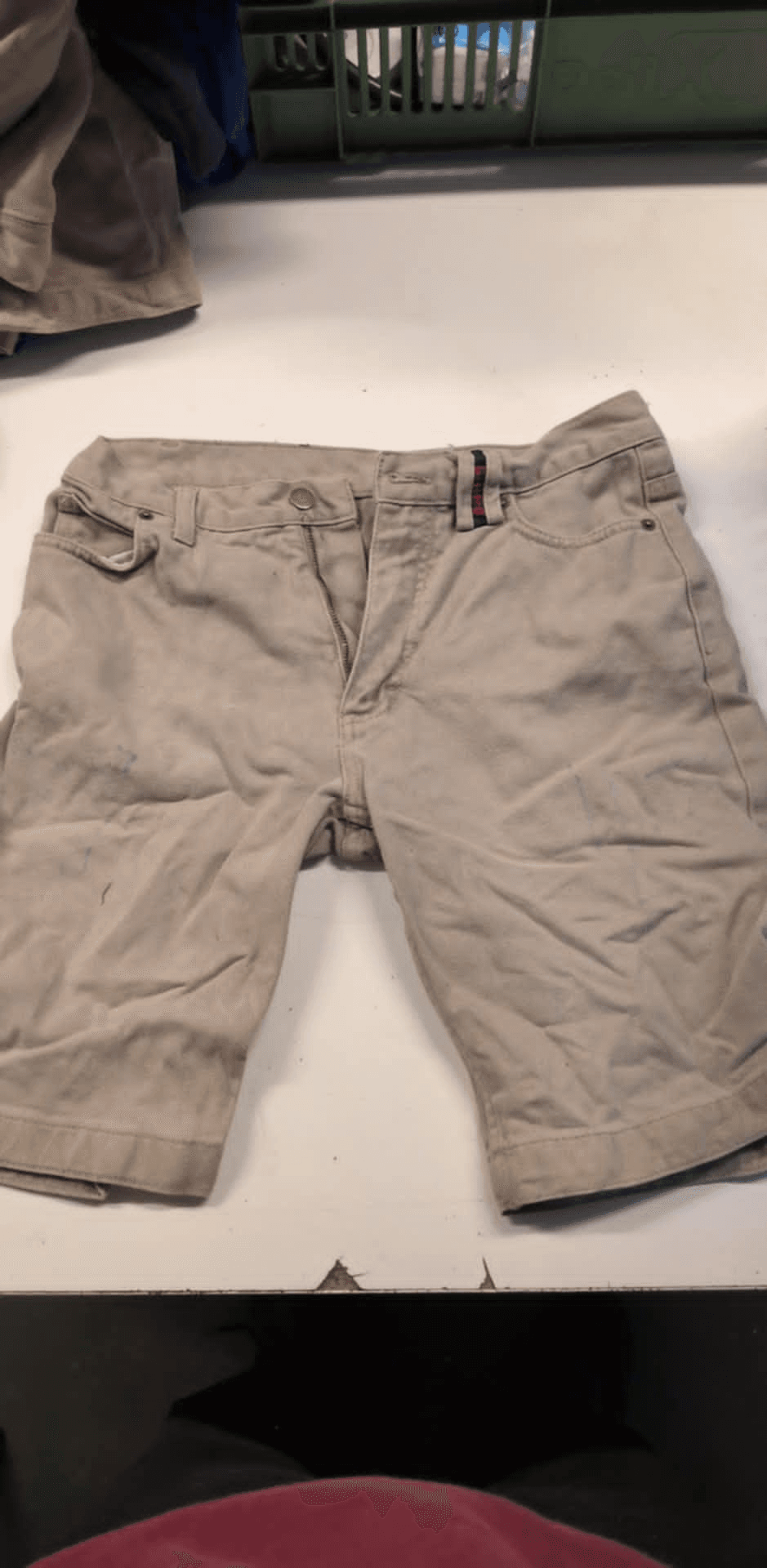 a pair of khaki shorts on a white table