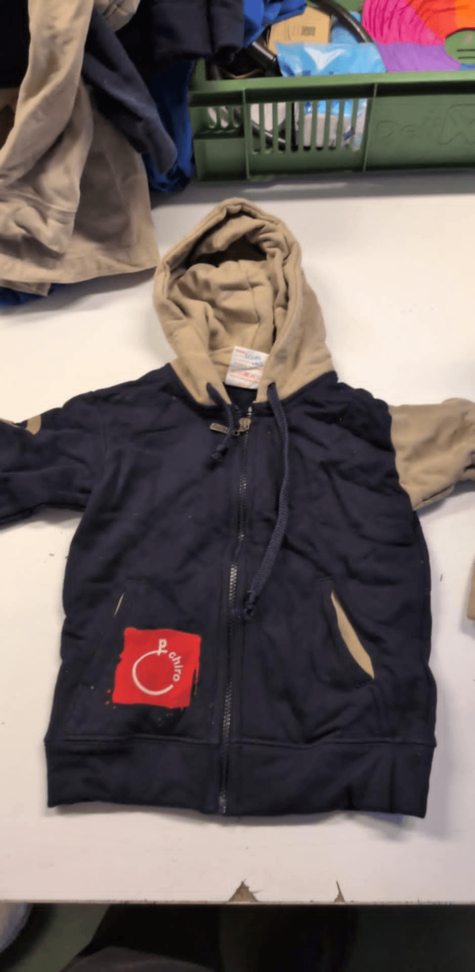 a blue and tan hoodie with a red patch that says ' i love you ' on it