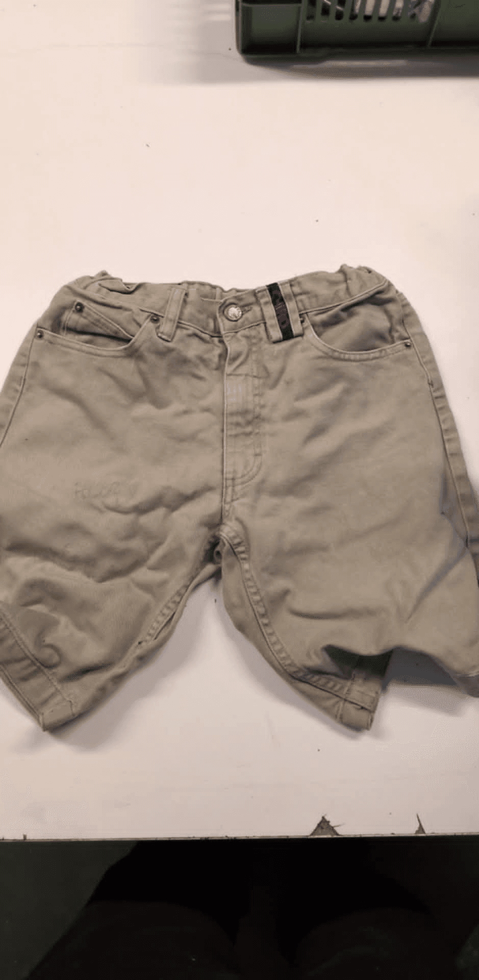 a pair of khaki shorts on a white table