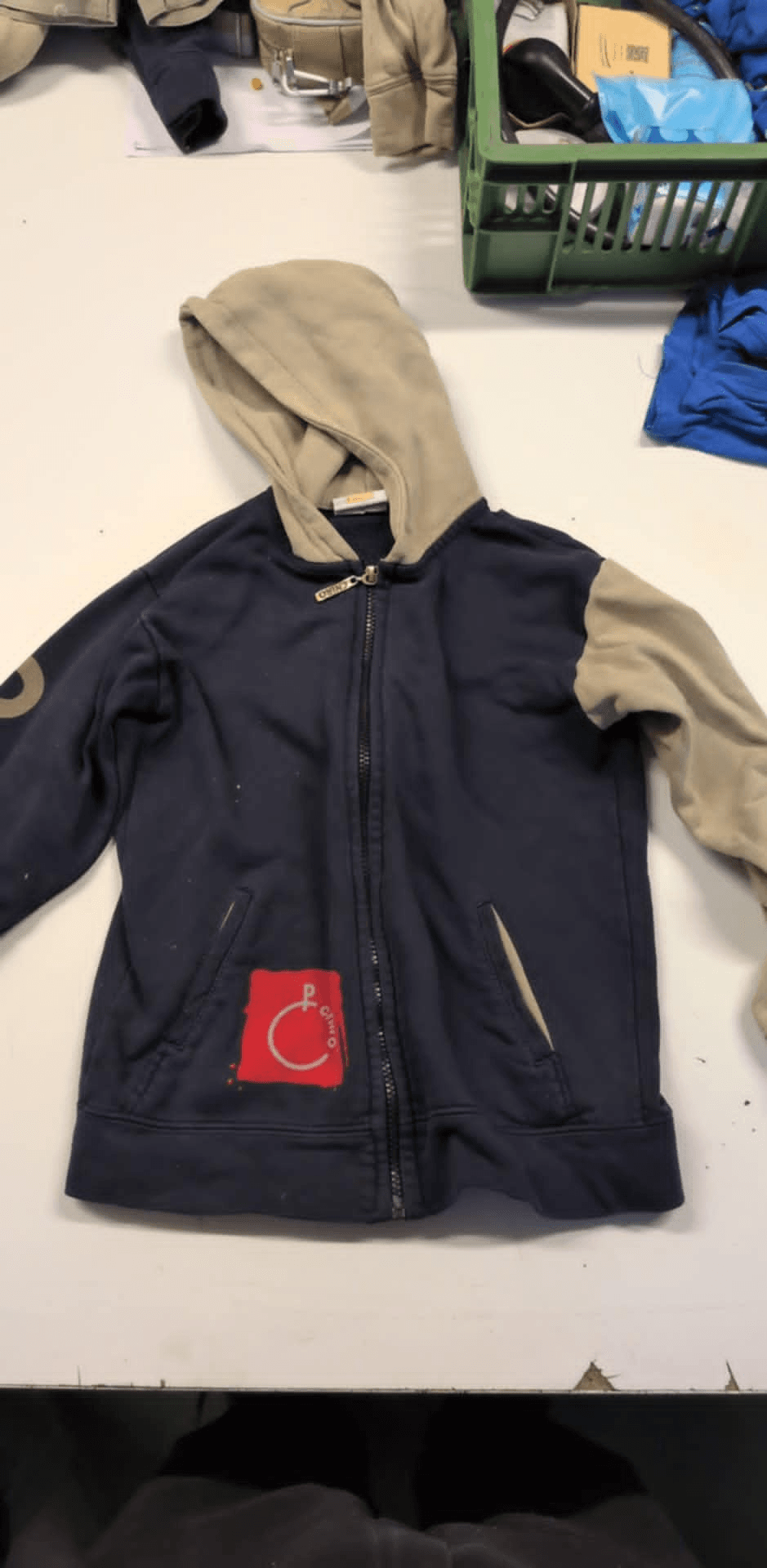 a hoodie with a red c on the pocket